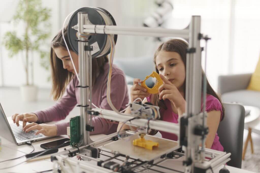 Young girls learning to use 3D printer at home